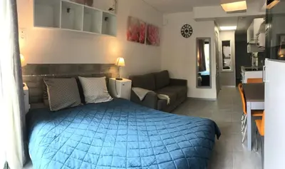 a bedroom with a blue bed and a living room at SOPHIES HOMES FÉLIBRIGES BEACH & PALAIS des FESTIVALS in Cannes