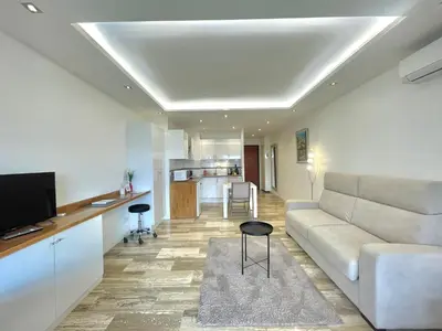 a living room with a couch and a kitchen at Studio Grand hôtel Croisette, by Welcome to Cannes in Cannes