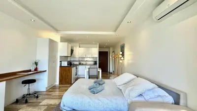 a living room with a bed and a kitchen at Studio Grand hôtel Croisette, by Welcome to Cannes in Cannes