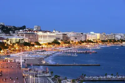 a view of a city with a beach at night at Coeur de Cannes - 2 pièces moderne in Cannes