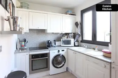 a kitchen with white cabinets and a washing machine at Coeur de Cannes - 2 pièces moderne in Cannes