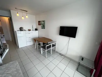 a kitchen with a table and a television on a wall at Cannes - view Cap Esterel in Cannes