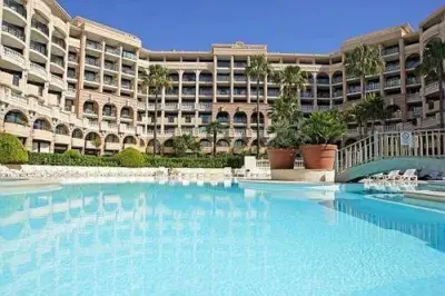 a large building with a large pool in front of it at Cannes - view Cap Esterel in Cannes
