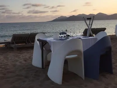 a table with wine glasses on the beach at Cannes - view Cap Esterel in Cannes