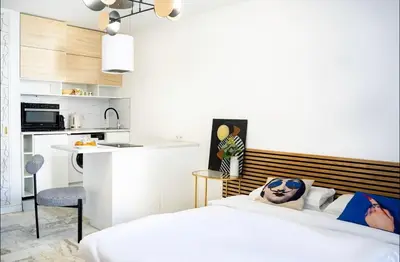 a bedroom with a bed and a kitchen at Majestic Apartment in Cannes