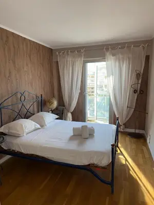 a bedroom with a bed with white sheets and a window at Villa Rimbaud in Cannes