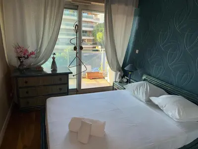a bedroom with a white bed with a window at Villa Rimbaud in Cannes
