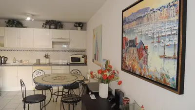 a kitchen with a table and chairs and a painting on the wall at CANNES Palazzio in Cannes