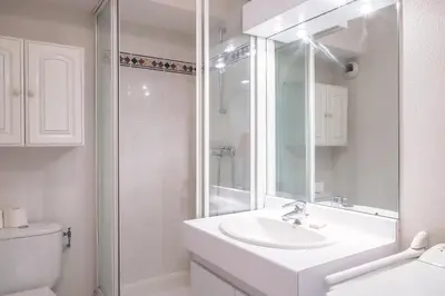 a white bathroom with a sink and a shower at CANNES Palazzio in Cannes