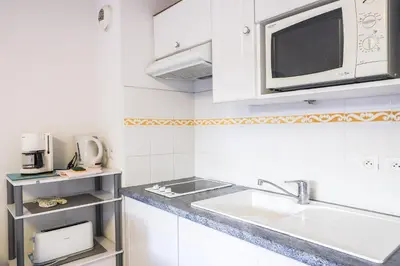 a white kitchen with a sink and a microwave at CANNES Palazzio in Cannes