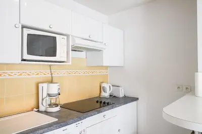 a kitchen with white cabinets and a microwave at CANNES Palazzio in Cannes