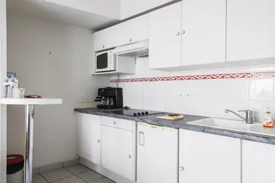 a white kitchen with white cabinets and a sink at CANNES Palazzio in Cannes