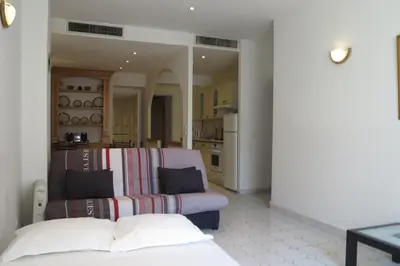 a living room with a couch and a kitchen at Viva Riviera - 5 Rue Commandant André in Cannes