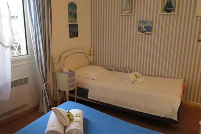 a small bedroom with two beds and a window at Viva Riviera - 5 Rue Commandant André in Cannes
