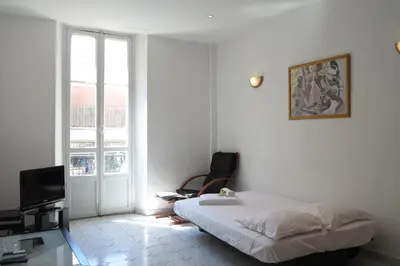 a bedroom with a bed and a tv and a window at Viva Riviera - 5 Rue Commandant André in Cannes