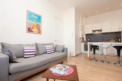 a living room with a couch and a kitchen at Apartment29 in Cannes