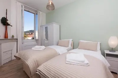 two beds in a room with a window at Apartment29 in Cannes