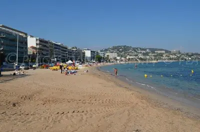 a beach with a lot of people and the ocean at Appartement Residence Athena in Cannes
