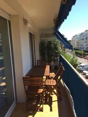 a balcony with a wooden table and chairs on a balcony at Immeuble le St Honorat in Cannes