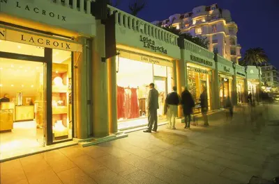 a group of people walking down a street in front of stores at Un coin de campagne en ville in Le Cannet