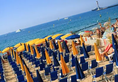 a bunch of chairs and umbrellas on a beach at Un coin de campagne en ville in Le Cannet