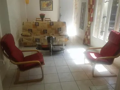a room with two chairs and a table and boxes at Un coin de campagne en ville in Le Cannet