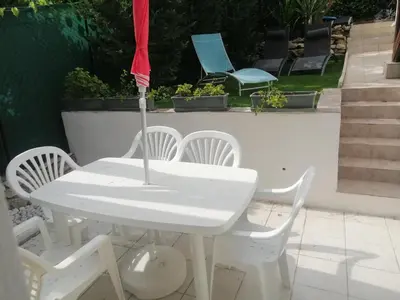 a white table and chairs with an umbrella at Un coin de campagne en ville in Le Cannet