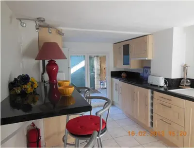 a kitchen with two chairs and a table with a lamp at Un coin de campagne en ville in Le Cannet