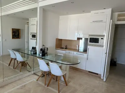a kitchen with a glass table and white appliances at CROISETTE Palais MIRAMAR FRONT DE MER in Cannes