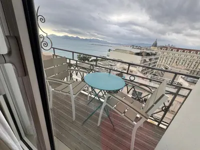 a balcony with a table and chairs and the ocean at CROISETTE Palais MIRAMAR FRONT DE MER in Cannes