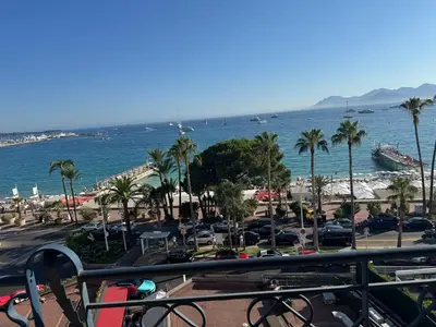 a view of a beach with palm trees and the ocean at CROISETTE Palais MIRAMAR FRONT DE MER in Cannes