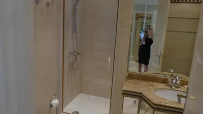 a woman taking a picture of a shower in a bathroom at CROISETTE Palais MIRAMAR FRONT DE MER in Cannes