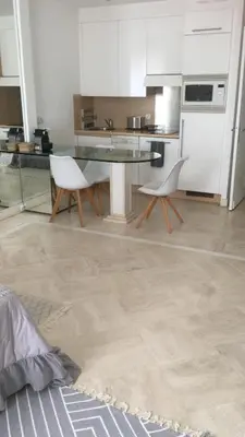 a kitchen with a table and two white chairs at CROISETTE Palais MIRAMAR FRONT DE MER in Cannes