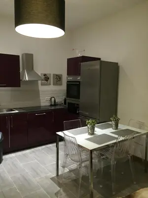 a kitchen with a table with chairs and a refrigerator at CANNES CROISETTE b in Cannes