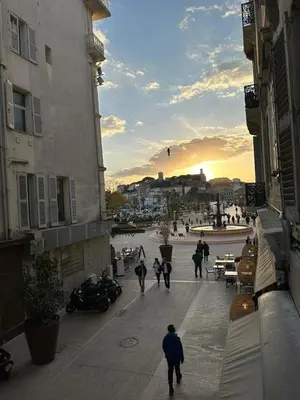 a group of people walking down a street at sunset at CANNES CROISETTE b in Cannes