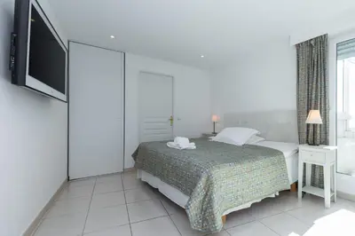a white bedroom with a bed and a tv at Superb penthouse in centre of Cannes Stunning views air-conditioning internet Near the Palais 532 in Cannes