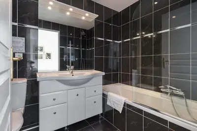 a black tiled bathroom with a sink and a tub at Superb penthouse in centre of Cannes Stunning views air-conditioning internet Near the Palais 532 in Cannes