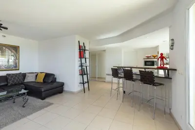 a living room with a black couch and a kitchen at Superb penthouse in centre of Cannes Stunning views air-conditioning internet Near the Palais 532 in Cannes