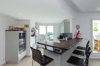 a kitchen with a wooden counter top and chairs at Superb penthouse in centre of Cannes Stunning views air-conditioning internet Near the Palais 532 in Cannes