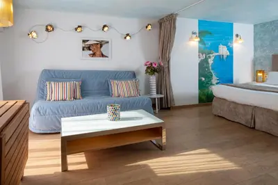a living room with a blue couch and a bed at Résidences Cresci in Cannes