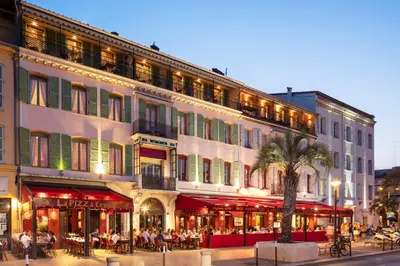 a large building with people sitting outside of it at Résidences Cresci in Cannes