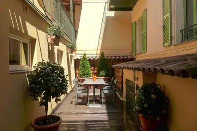 an outdoor patio with a table and chairs on a building at Résidences Cresci in Cannes