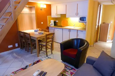 a kitchen and dining room with a table and a chair at Résidences Cresci in Cannes