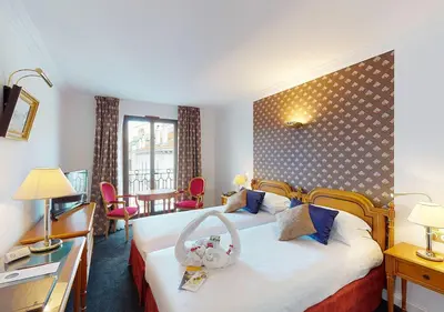 a hotel room with a bed and a table and chairs at Sun Riviera Hotel in Cannes