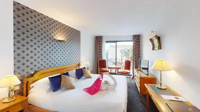 a hotel room with a bed and a desk at Sun Riviera Hotel in Cannes