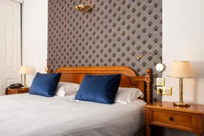 a bedroom with a bed with two blue pillows at Sun Riviera Hotel in Cannes
