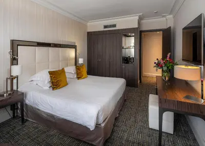 a hotel room with a large bed and a television at Hôtel Le Canberra in Cannes