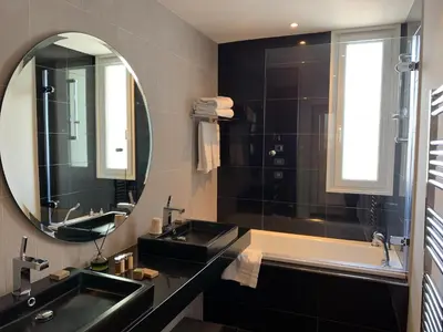 a bathroom with a black sink and a mirror at Hôtel Le Canberra in Cannes