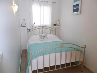 a small bedroom with a bed in a room with a window at Palais Rouaze in Cannes