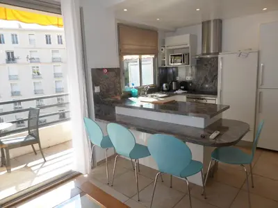 a kitchen with a counter with chairs and a counter top at Palais Rouaze in Cannes